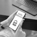 A black and white image showing white hands holding a phone